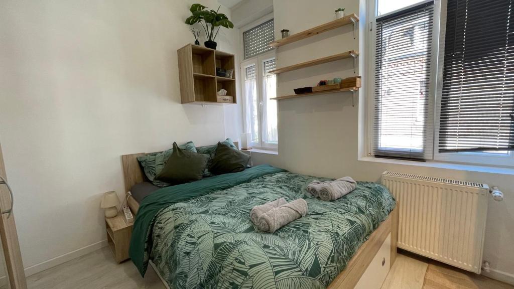 ein Schlafzimmer mit einem Bett mit zwei Kissen darauf in der Unterkunft La Tropicale de Croix - Chambre d'Hôtes in Croix