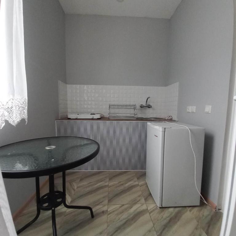 a small kitchen with a table and a refrigerator at Anna 2 in Kobuleti