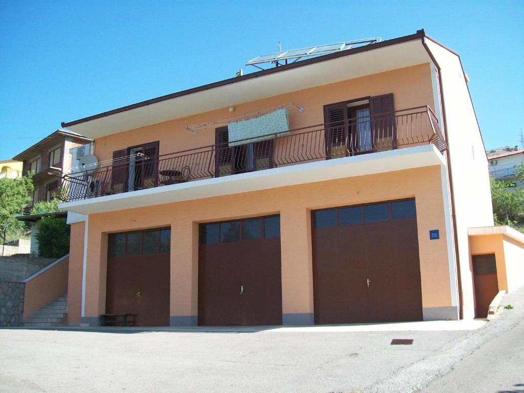 budynek z 4 drzwiami garażowymi i balkonem w obiekcie Rooms MUDRAC w mieście Senj