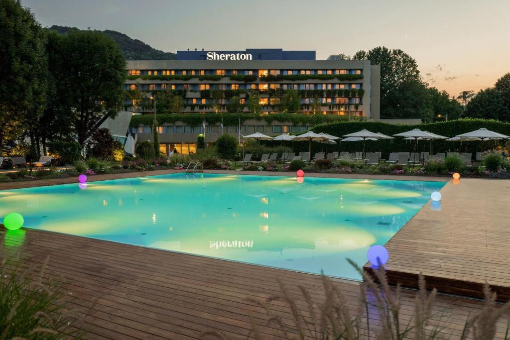 una gran piscina frente a un hotel en Sheraton Lake Como Hotel, en Como