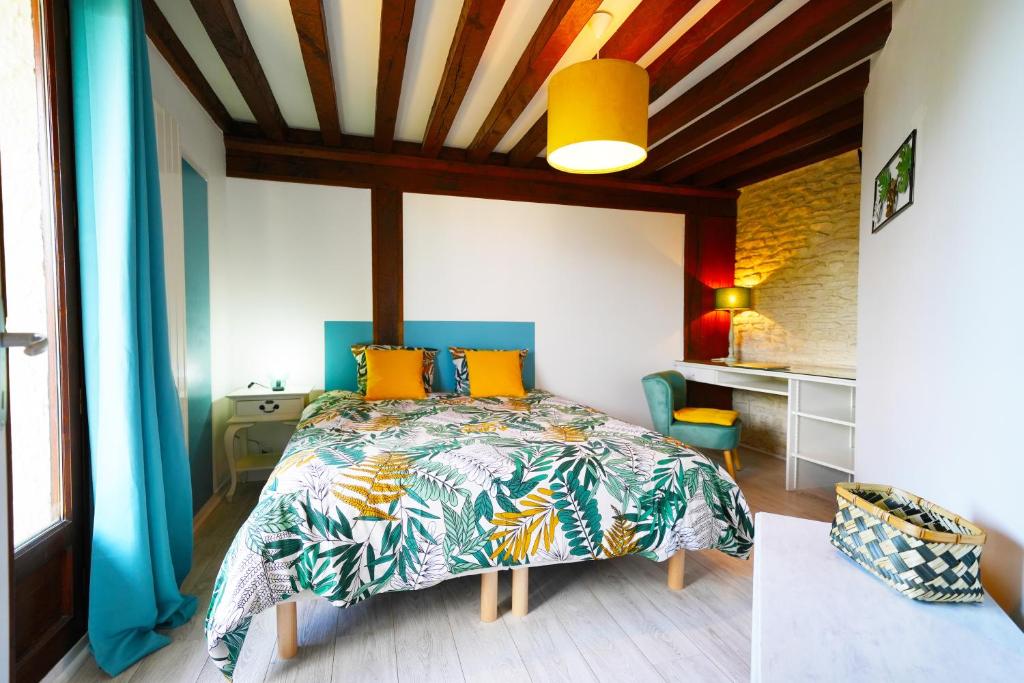 ein Schlafzimmer mit einem Bett mit einer farbenfrohen Tagesdecke in der Unterkunft Cosy Zénith in Caen