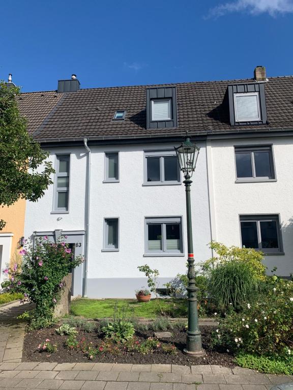 a white house with windows and a street light at City-Apartment Düsseldorf in Düsseldorf