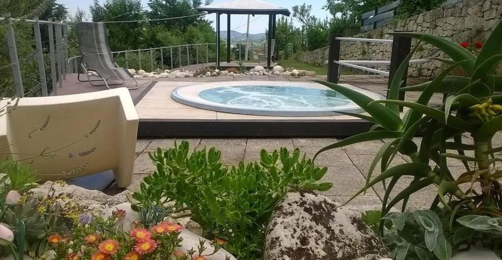 a small pool in a garden with a swing at Casa di Principe - Piazza in Lettomanoppello