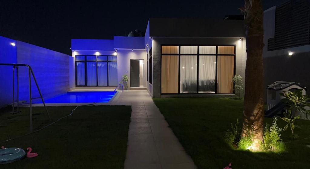 a house at night with blue lights at شاليه خاص فندقي و مستقل in Riyadh