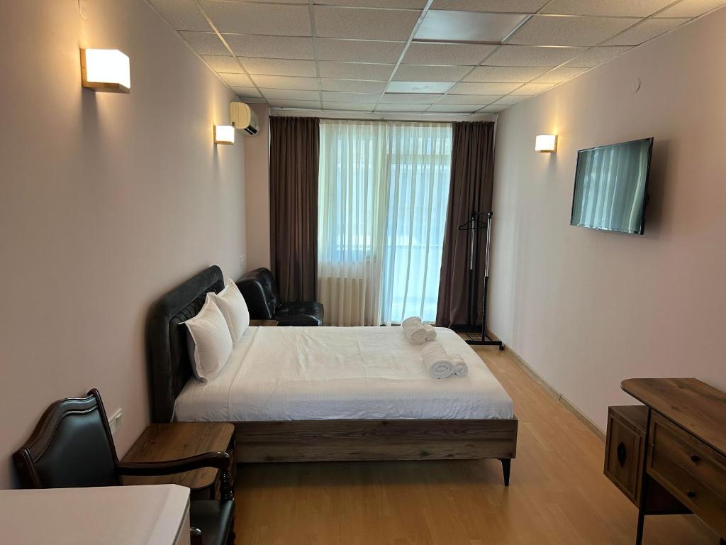 een hotelkamer met een bed en een raam bij Hotel Four Season in Tbilisi City