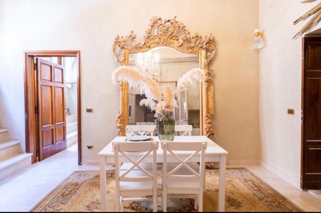 una sala da pranzo con specchio e sedie bianche di Casa Matilde a Montepulciano