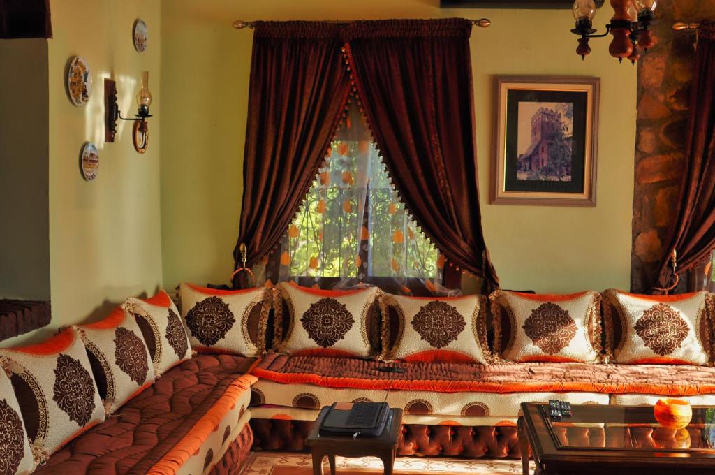 a couch with pillows in front of a window at Villa Authentique avec Vue Panoramique à 3 km de Chefchaouen in Chefchaouen