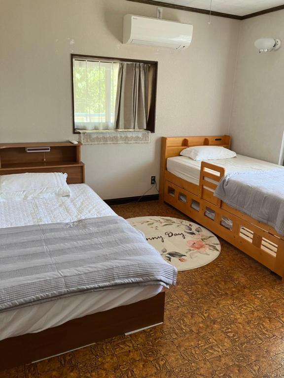 1 dormitorio con 2 camas y ventana en 癒しのwonderland 泉, en Gujō