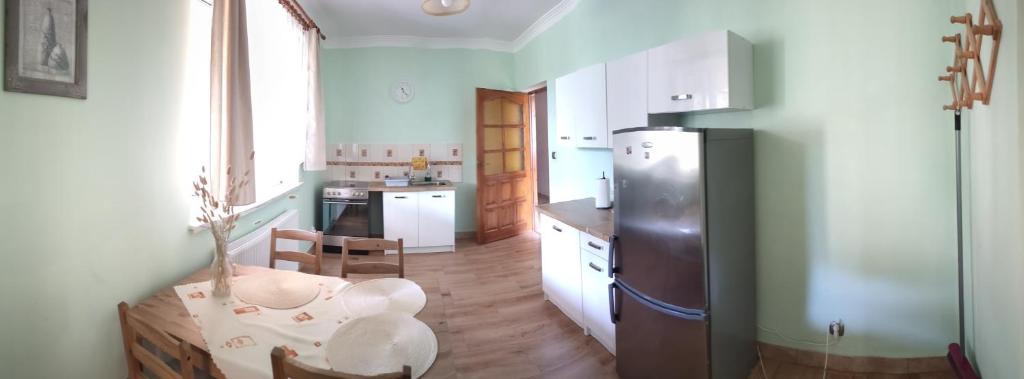 a kitchen with a refrigerator and a table in it at Cichy Zakątek Kłodzko in Kłodzko