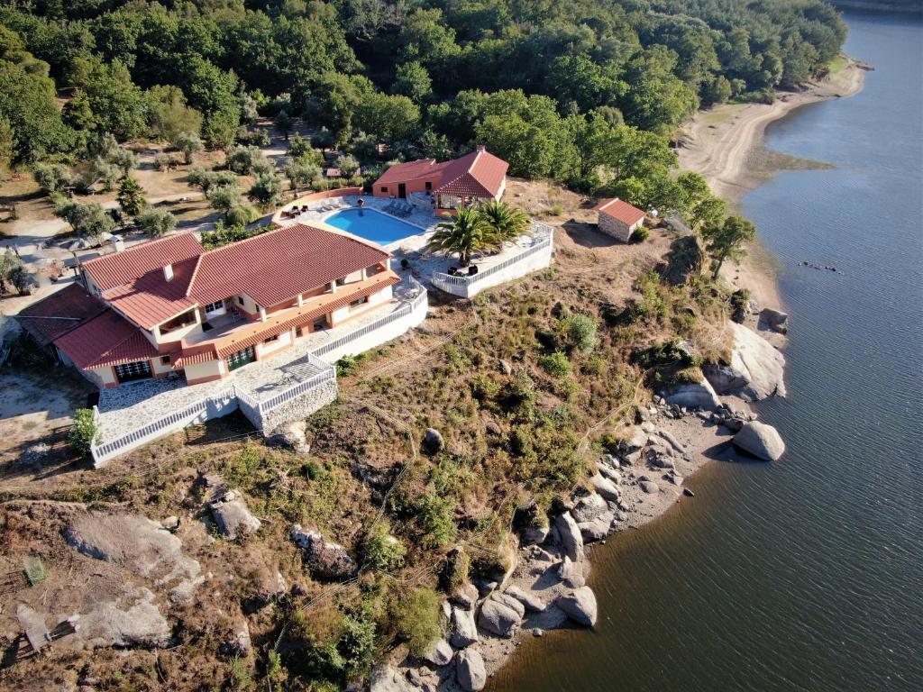 una vista aérea de una casa en una isla rocosa en Encontro no Rio, en Póvoa de Midões