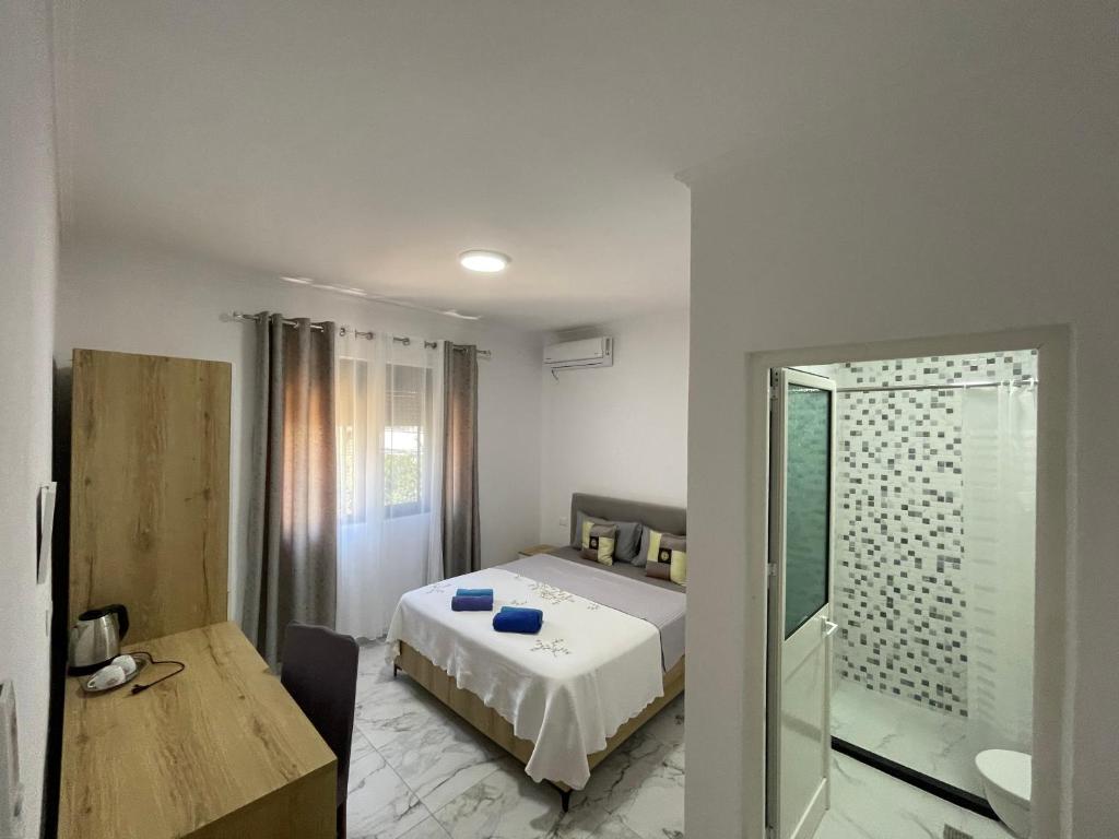 a bedroom with a bed and a glass shower at Vila Gashi in Durrës