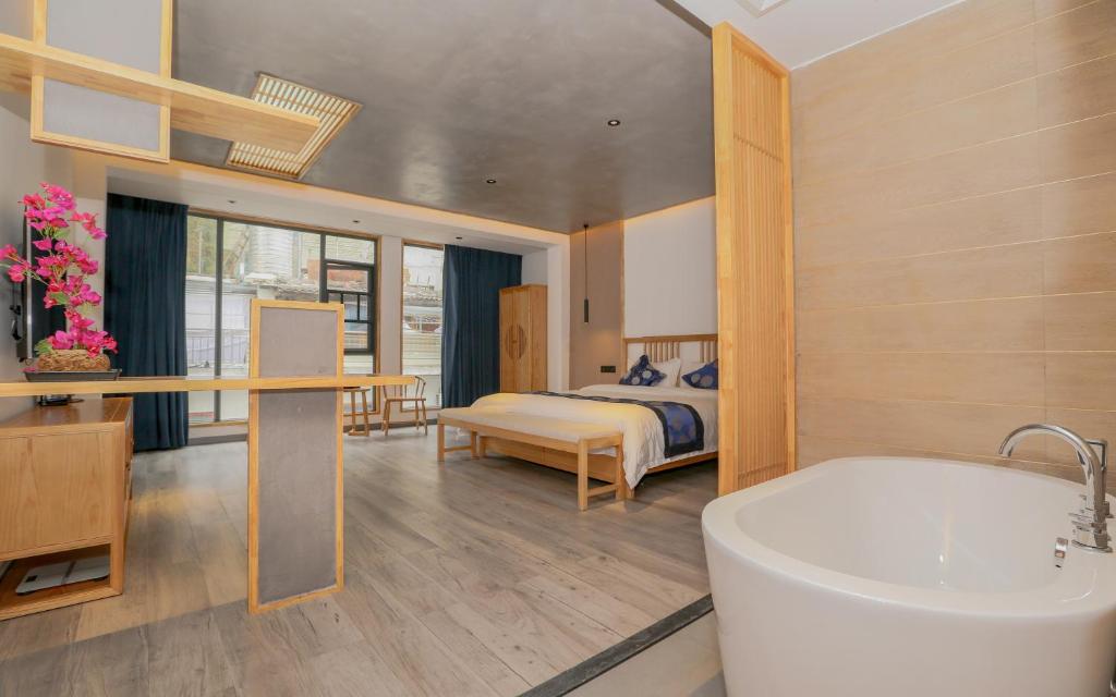 a bathroom with a tub and a bedroom with a bed at Cozy Boutique Hotel in Zhangjiajie