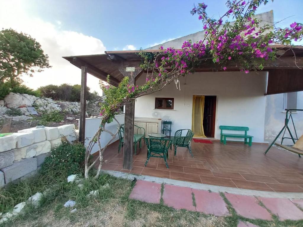 eine Terrasse mit einem Tisch und Stühlen vor einem Haus in der Unterkunft Domo Clelia in Nulvi