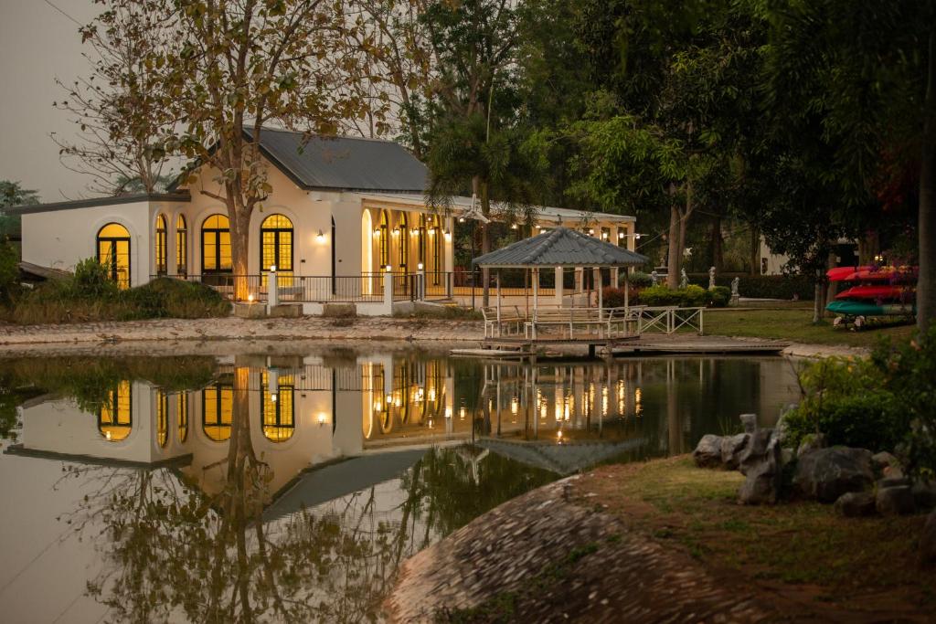 une maison assise à côté d'une nappe d'eau dans l'établissement Diamond Hill Resort, à Nong Nam Daeng