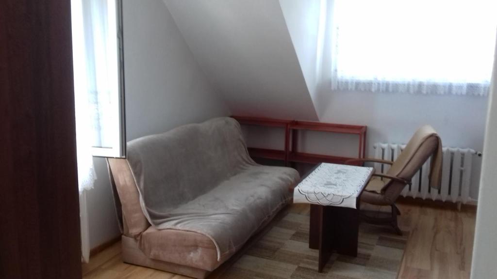 ein Wohnzimmer mit einem Sofa und einem Stuhl in der Unterkunft urocze mieszkanko na nowoczesnym osiedlu w Bielsku-Białej in Bielsko-Biała