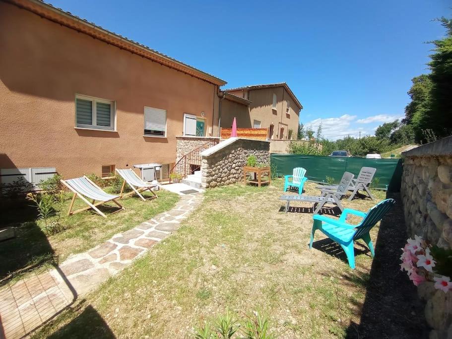 a yard with chairs and a house and water at Appartement neuf tout confort in Aubenas