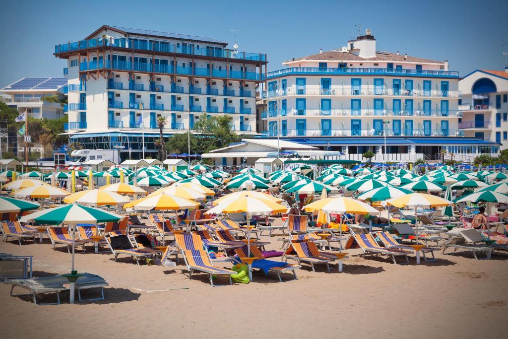 un grupo de sillas y sombrillas en una playa en Hotel Playa e Mare Nostrum, en Caorle