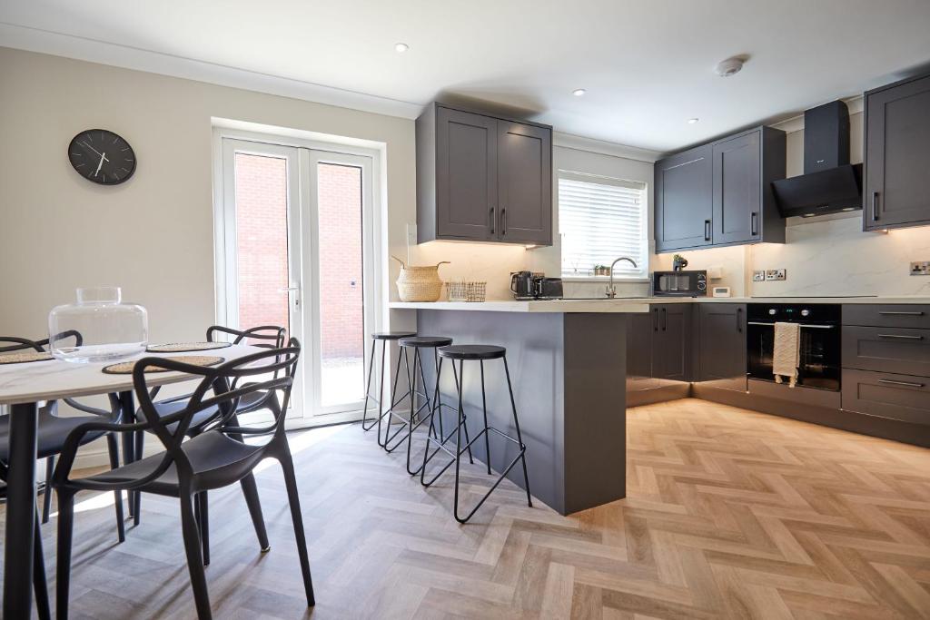 a kitchen with a table and some chairs and a table and a counter at Freshly Refurbished Open-plan Dining & Kitchen in Norwich