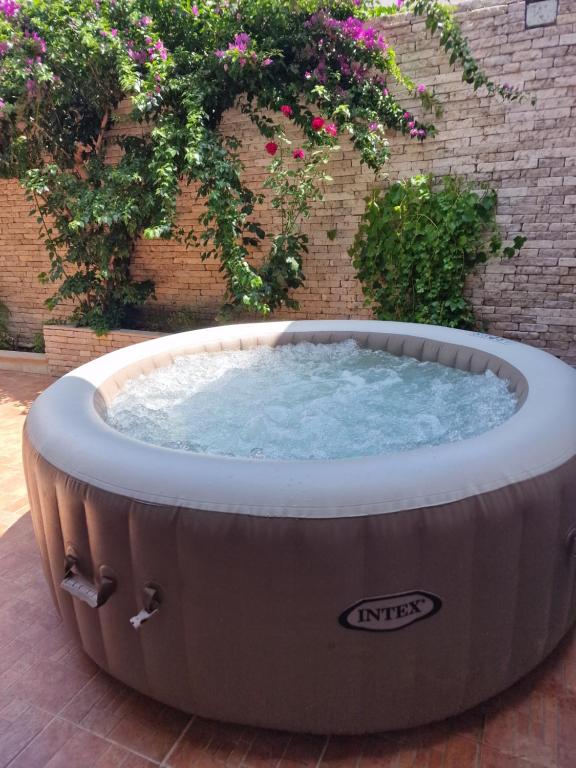 a large hot tub in a yard with flowers at Nel Cuore di Campomarino in Campomarino