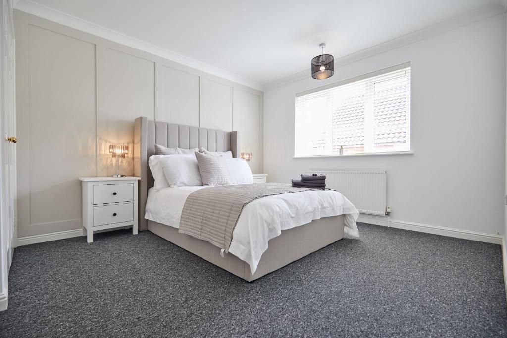 a white bedroom with a large bed and a window at Freshly Refurbished Open-plan Dining & Kitchen in Norwich