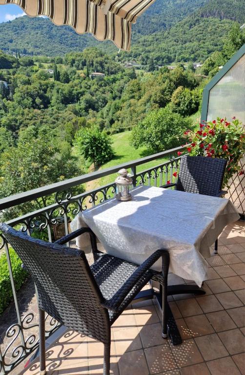 a table and chairs on a balcony with a view at G&B Apartments in Tignale