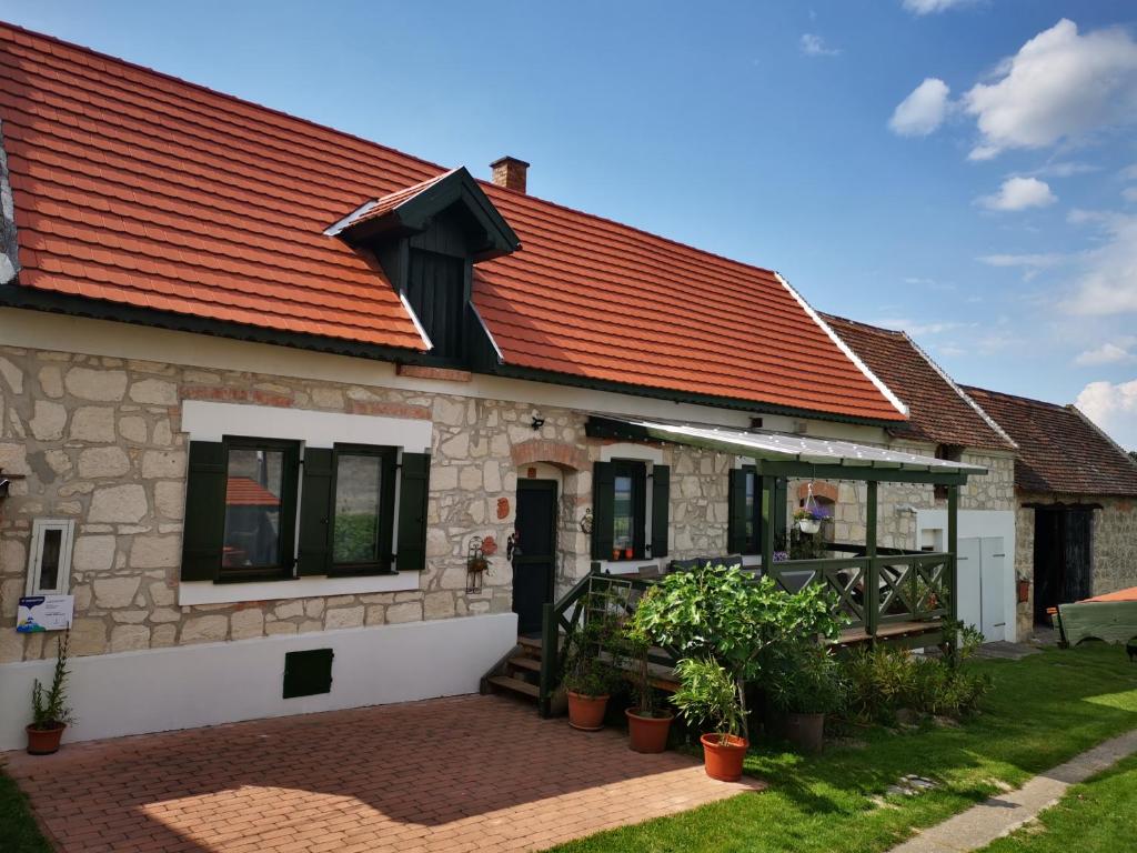 una casa con tetto rosso e patio di Kőfejtő háza a Fertőrákos