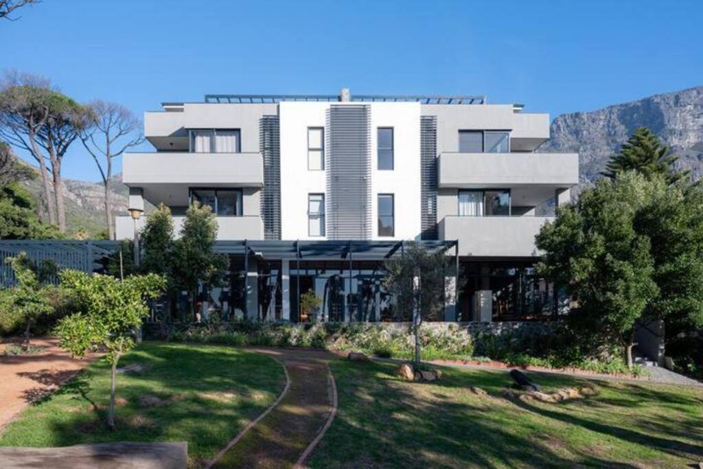 un gran edificio blanco con césped delante en Deer Park Apartment CPT - With Sweeping Views, en Ciudad del Cabo