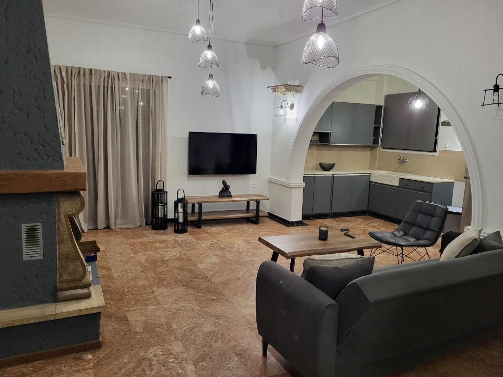 - un salon avec un canapé et une télévision dans l'établissement Dilion Guest House, à Dhílesi