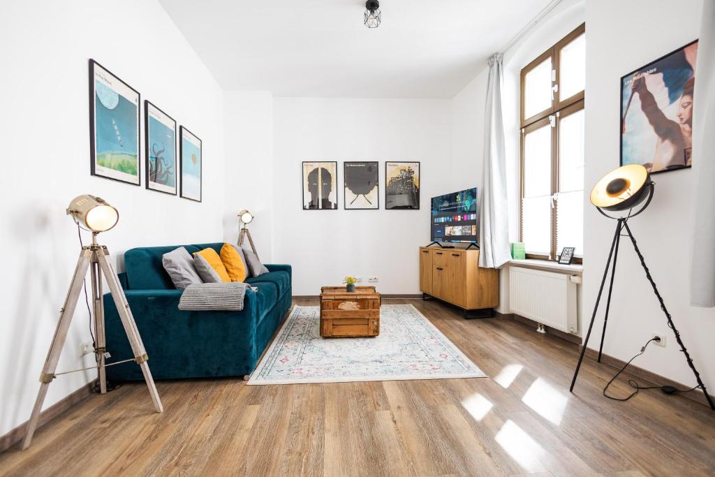 een woonkamer met een blauwe bank en een raam bij Ko-Living Space am Neuen Theater - einzigartige Unterkünfte mit Stil in Halle an der Saale