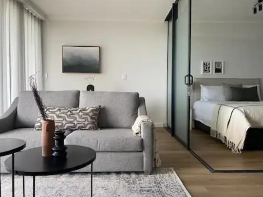a living room with a couch and a bed at Newlands Peak - Spacious one-bed apartment in Cape Town
