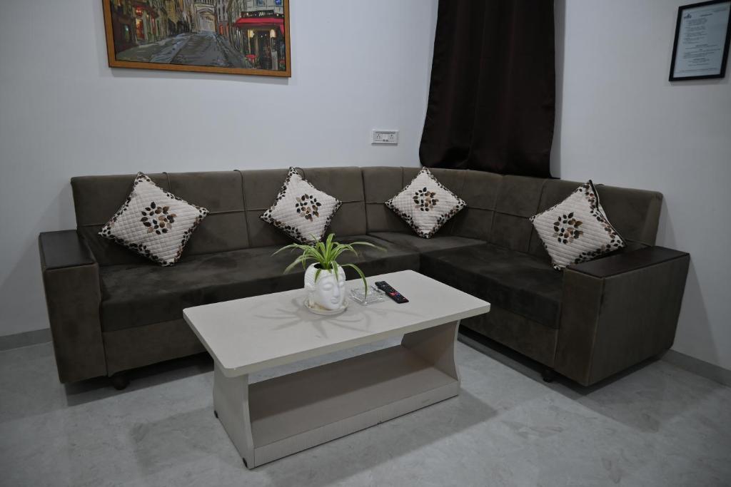 Una sala de estar con un sofá y una mesa de café. en Staeg 102-1Bhk Furnished Apt, en Indore
