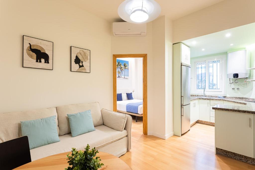 a living room with a couch and a kitchen at Holidays2Malaga Victoria 40 Quiet & Central in Málaga