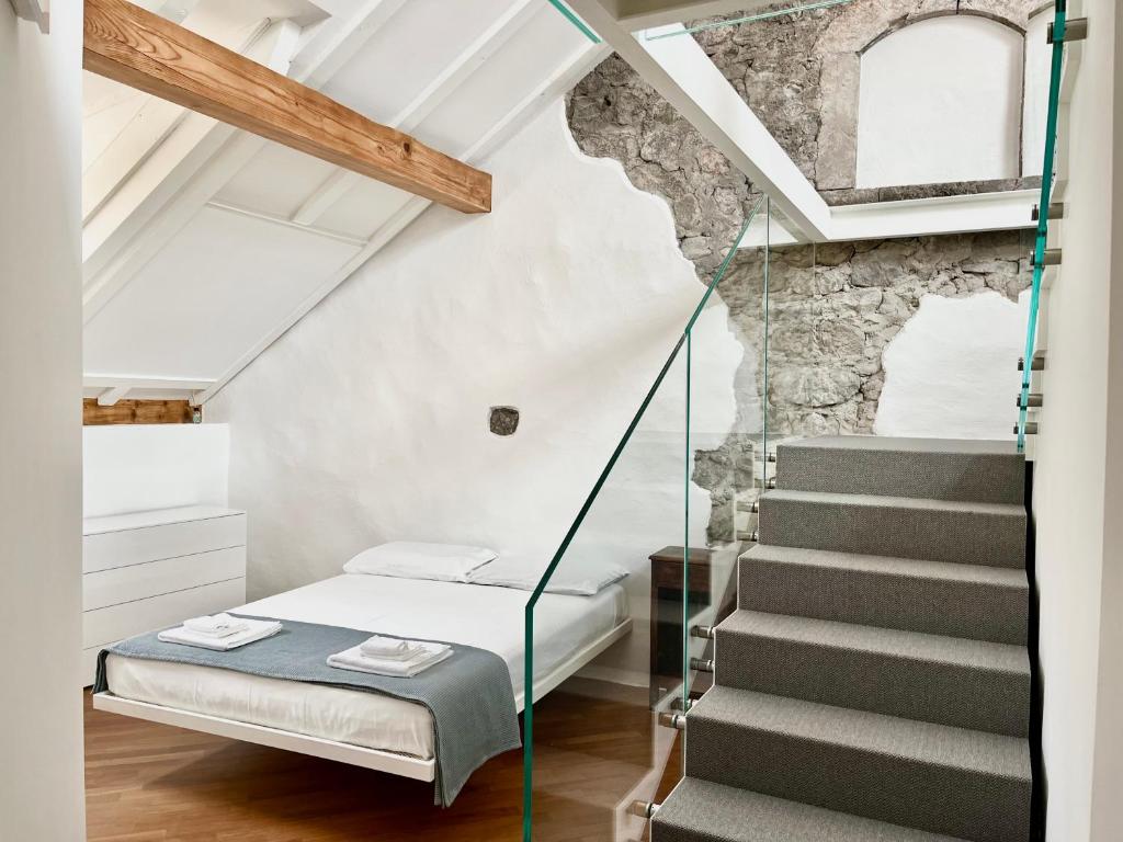 Habitación con cama y escalera de cristal en Historic Rooms and Apartments in the City Centre of Bolzano, en Bolzano