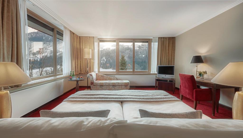 a hotel room with a bed and a living room at Lebenberg Schlosshotel-Kitzbühel in Kitzbühel