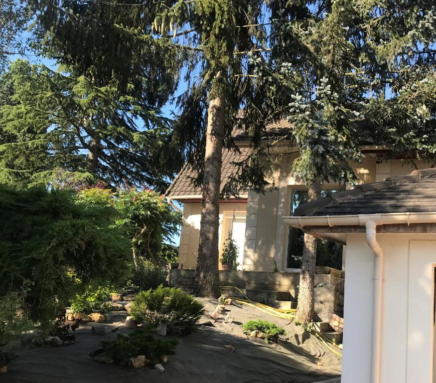 une maison avec un arbre dans la cour dans l'établissement Luxury Villa - LA JACHERE, à Épinay-sous-Sénart