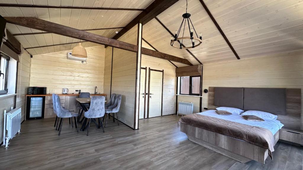 a bedroom with a bed and a table and chairs at Гостинично-банный комплекс PARADISE in Shchūchīnsk