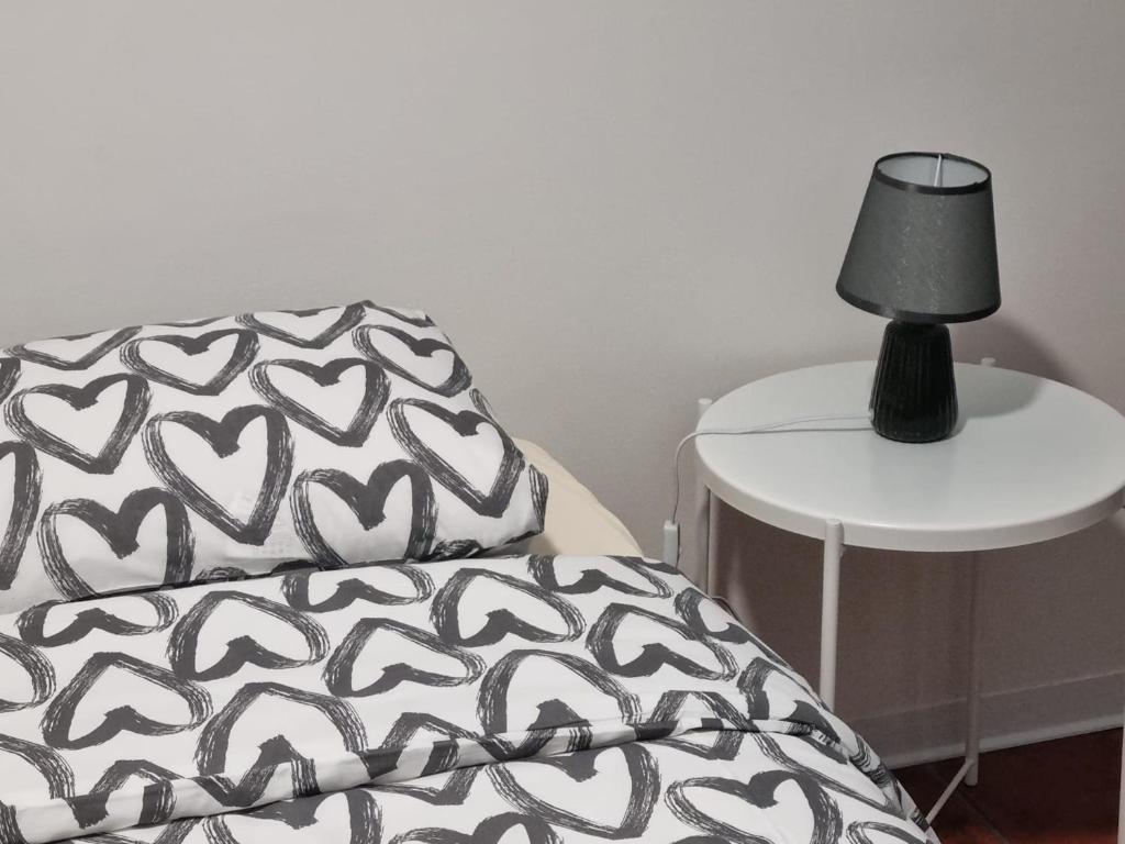 ein Bett mit einem Kissen und einer Lampe auf einem Tisch in der Unterkunft Alvorada Lunar in Almeirim