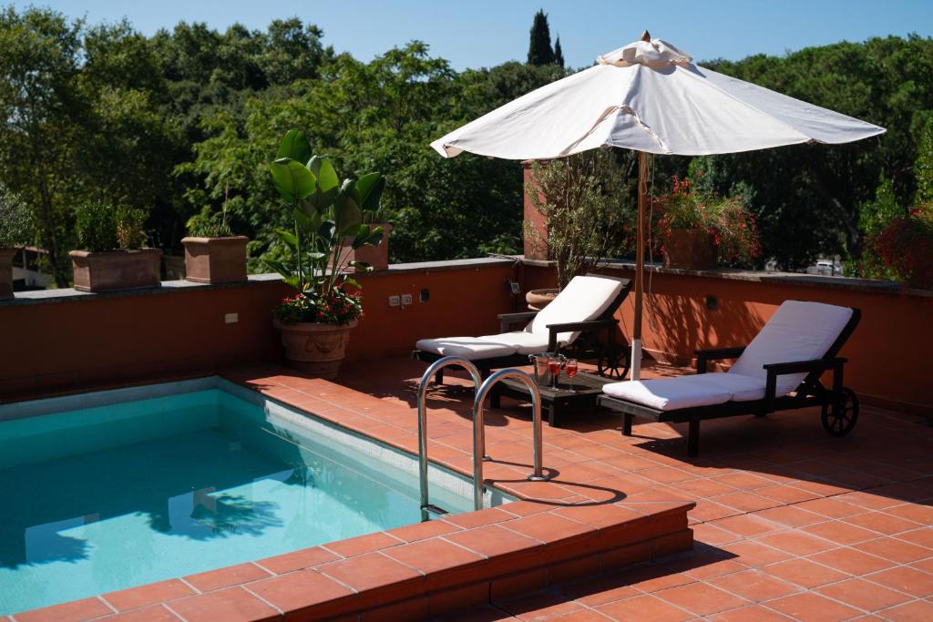 una piscina con due sedie e un ombrellone di Villa Terme di Caracalla with private Swimming Pool a Roma
