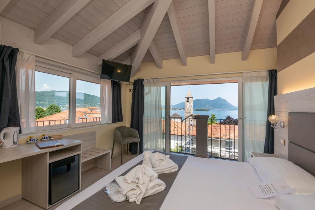 a bedroom with a bed and a desk with a window at Hotel Rosa in Baveno