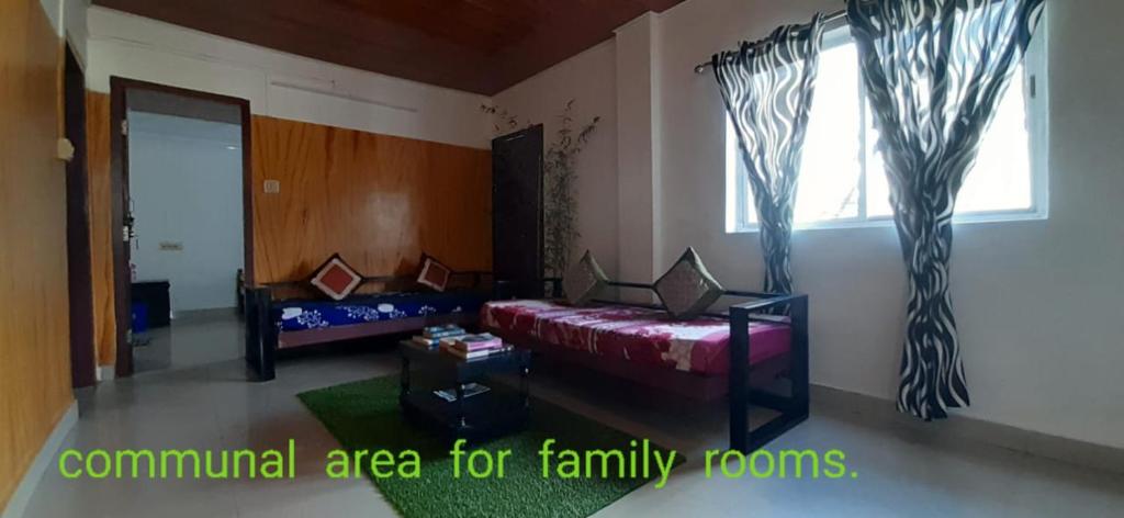 a living room with a bed and a window at Durga budget stay in Munnar