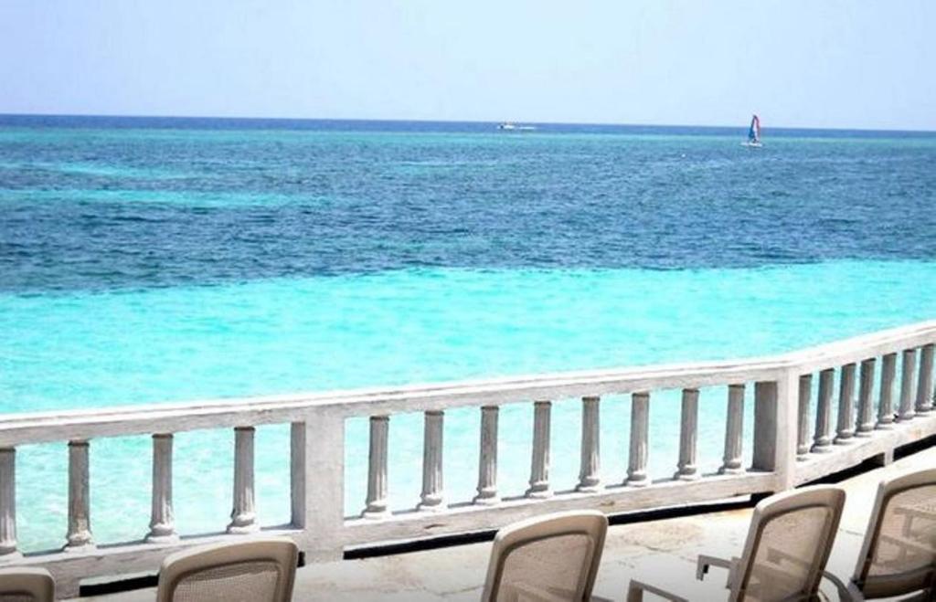 a view of the ocean from a balcony with chairs at Jamrock Secret Retreat in Montego Bay
