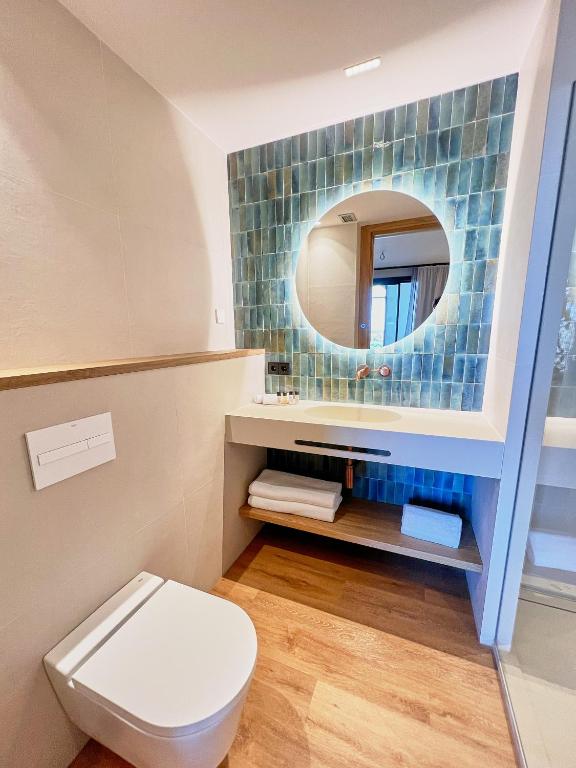a bathroom with a toilet and a mirror at Casa Indiana Hotel Boutique in Blanes