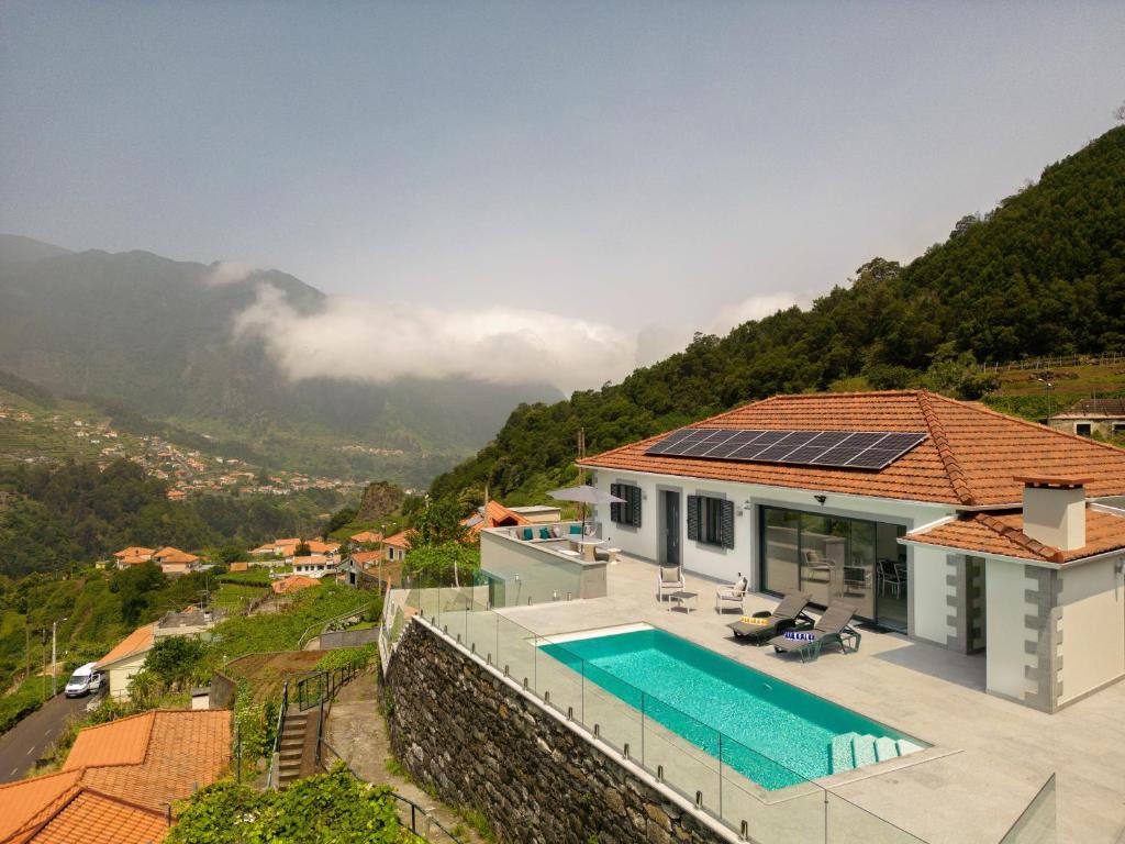 a house with a swimming pool and a mountain at Casa Avô da Pedra, By OP in São Vicente