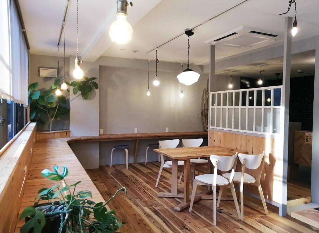 Ten to Sen Guesthouse في تاكاماتسو: غرفة طعام مع طاولة وكراسي خشبية
