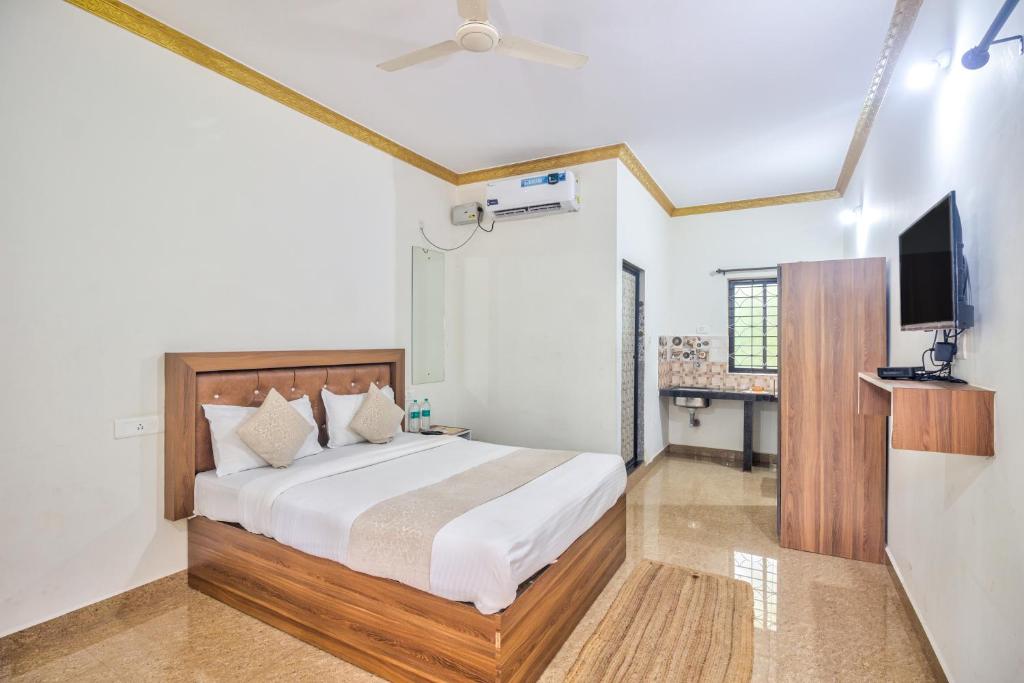 a bedroom with a bed and a flat screen tv at Calangute Bay By The Sea in Calangute