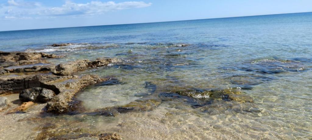 um grupo de rochas na água em uma praia em Avola Urban Stay em Avola
