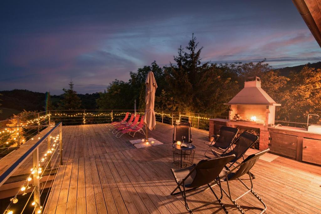 una terraza con sillas y un cenador con luces en Chill House Keti, 