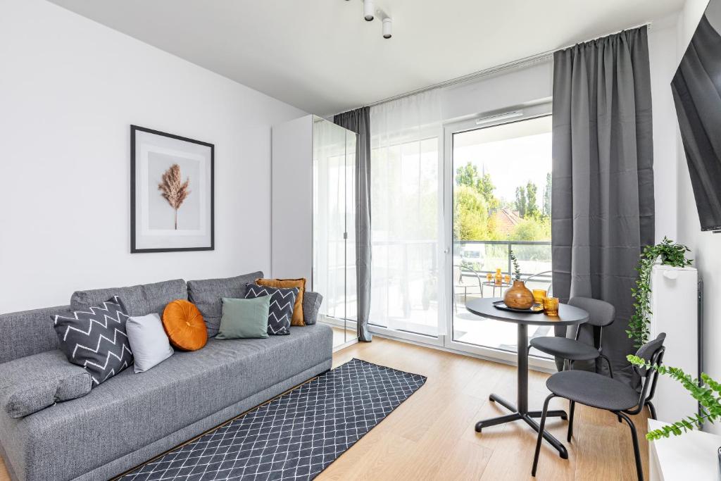a living room with a gray couch and a table at SuperApart Bokserska 71a MiniStudio - near Chopin Airport in Warsaw