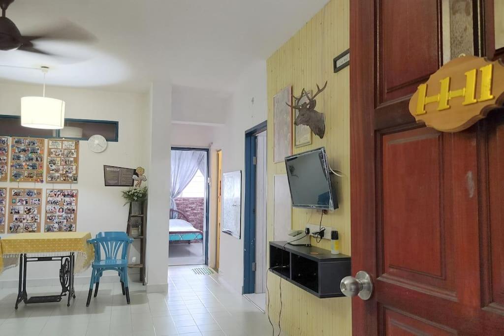 een woonkamer met een televisie en een tafel en stoelen bij Comfy Home Near to Penang Hill in Ayer Itam