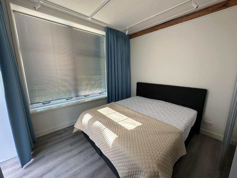 a small bedroom with a bed and a window at Golfbaan om de hoek! in Nieuwveen